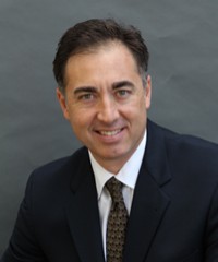 A picture of Rob Martinez, who is a man with dark brown hair in a formal suit. 